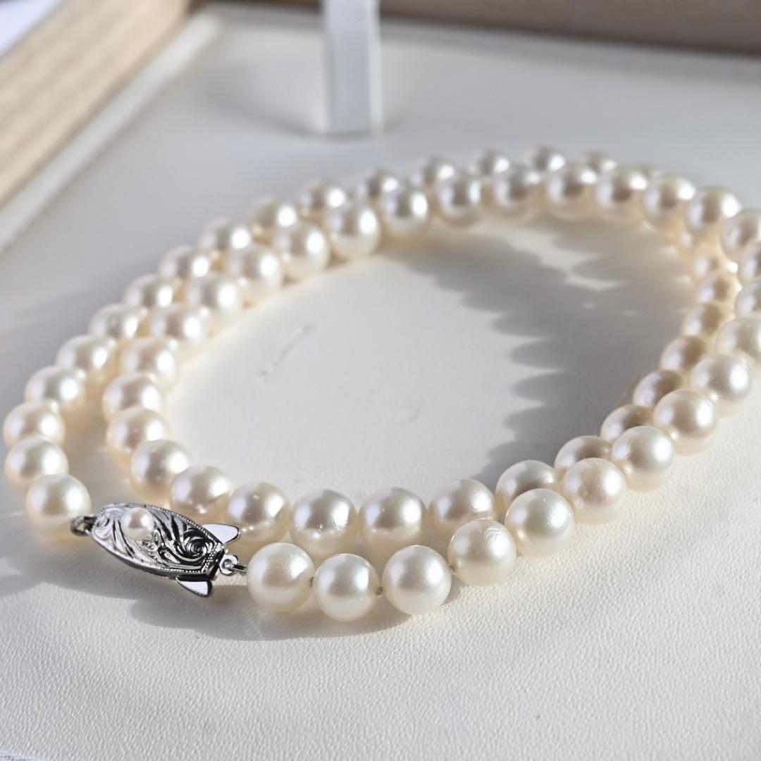 Tasaki Akoya Pearl Necklace featuring 7mm round pearls and a silver clasp on a white background