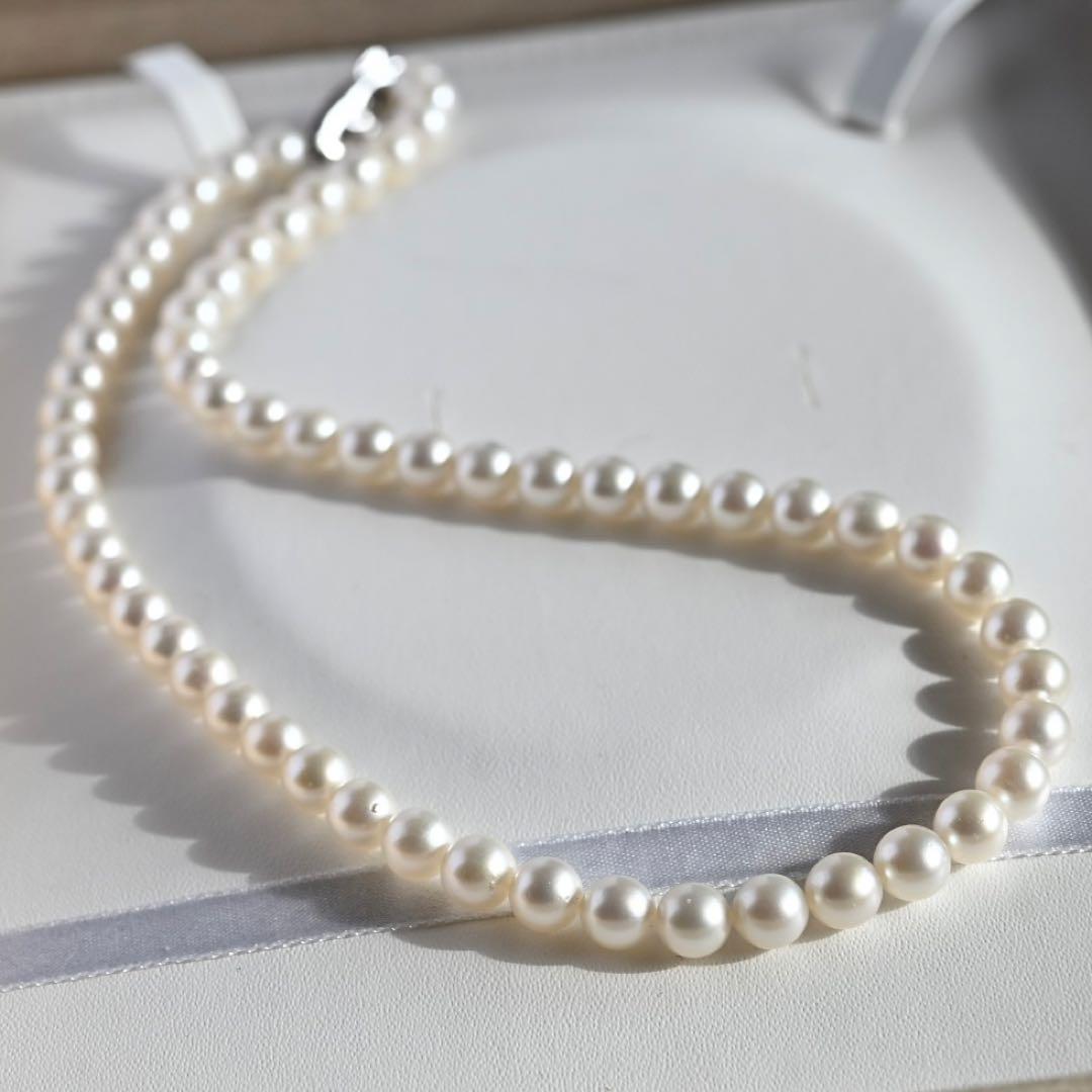 Tasaki Akoya Pearl Necklace featuring 7mm round pearls and a silver clasp on a white background