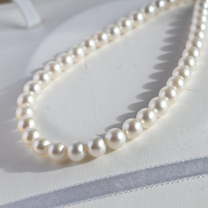 Tasaki Akoya Pearl Necklace featuring 7mm round pearls and a silver clasp on a white background