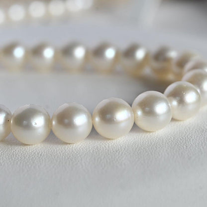 Tasaki Akoya Pearl Necklace featuring 7mm round pearls and a silver clasp on a white background