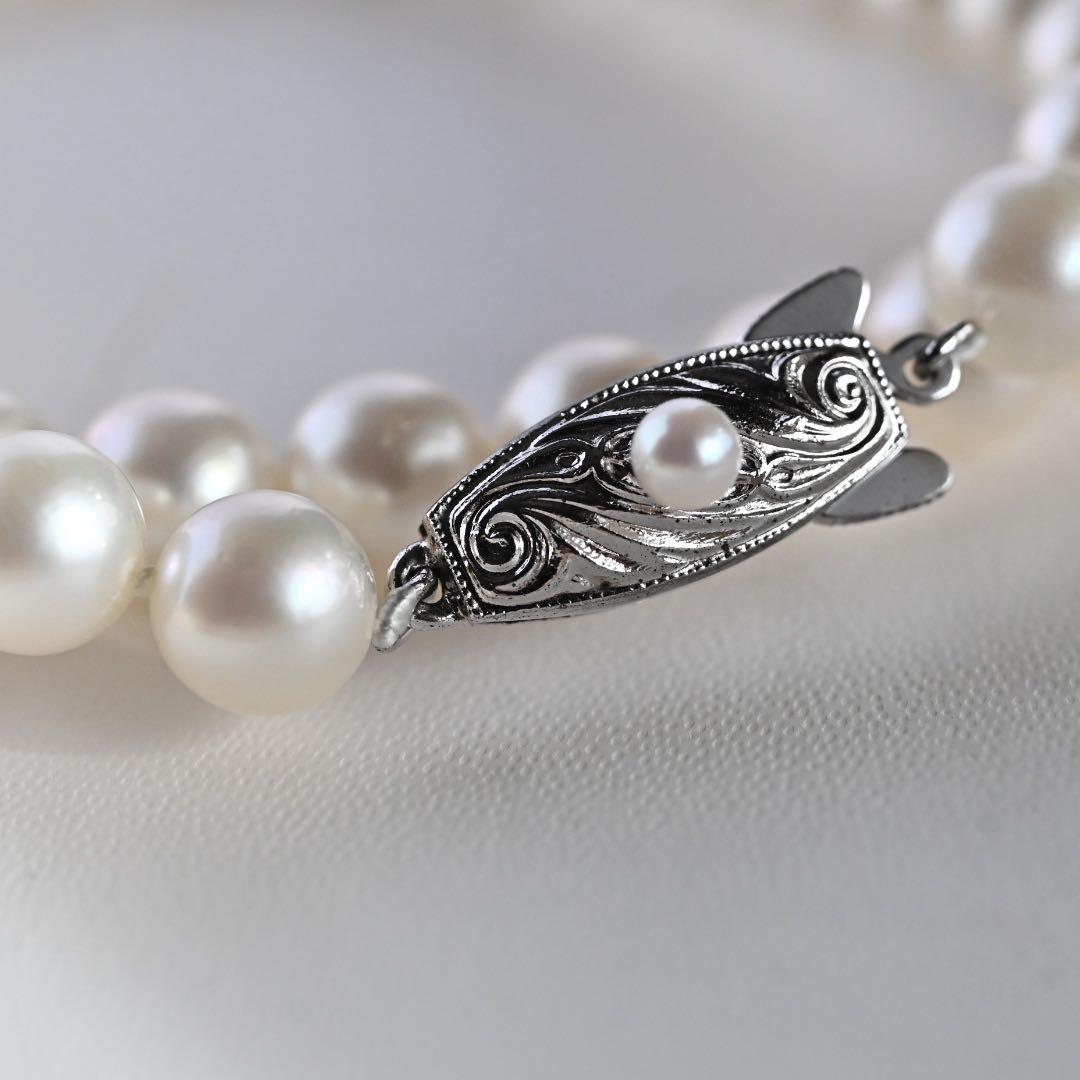 Tasaki Akoya Pearl Necklace featuring 7mm round pearls and a silver clasp on a white background