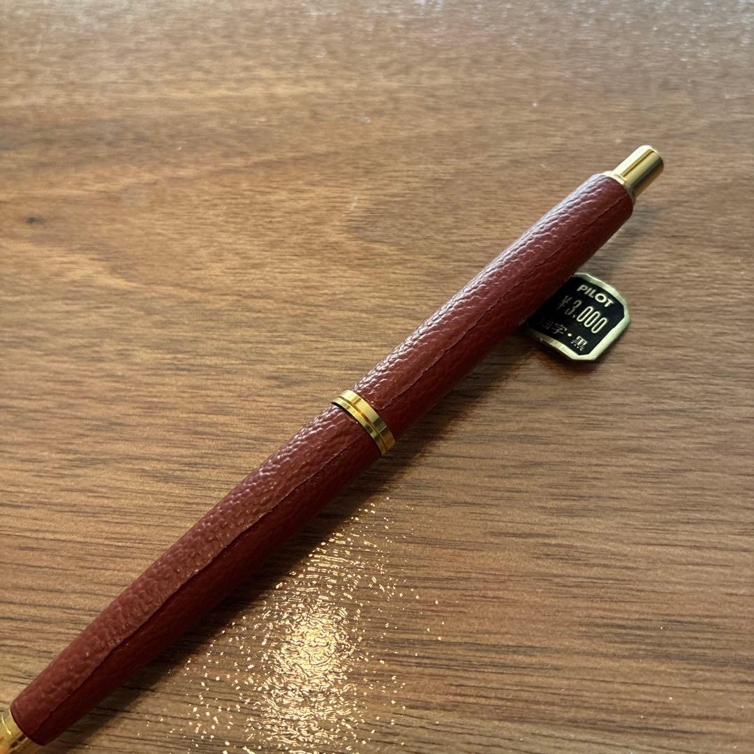 New PILOT high-end ballpoint pen with brown leather-like body and gold accents, fine point tip, black ink