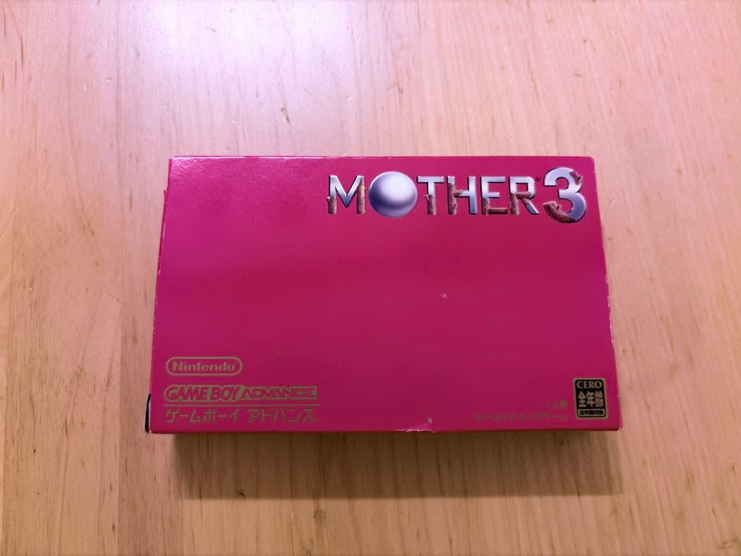 MOTHER3 Game Boy Advance game with outer box, inner box, and instruction manual showing slight box tears