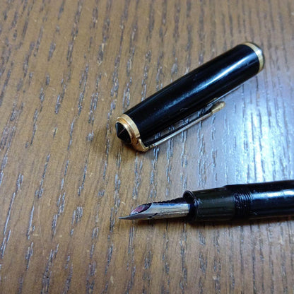 Vintage Pilot Plunger Fountain Pen with steel nib and slightly open clip on white background