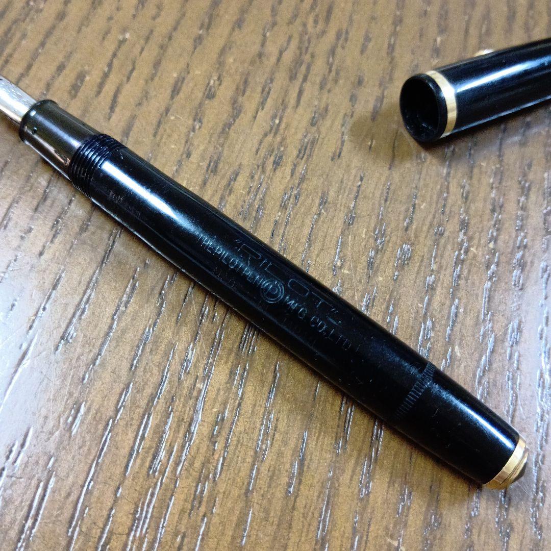 Vintage Pilot Plunger Fountain Pen with steel nib and slightly open clip on white background