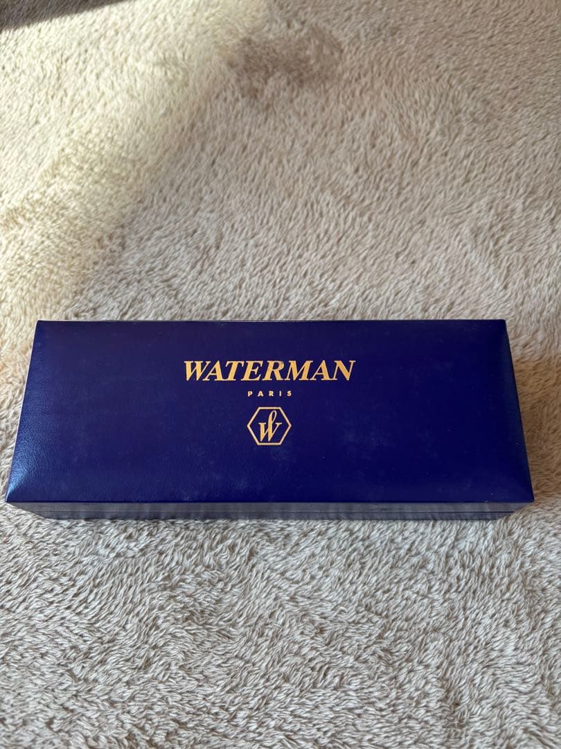 Brown WATERMAN fountain pen with logo, presented alongside a protective case and extra ink bottle