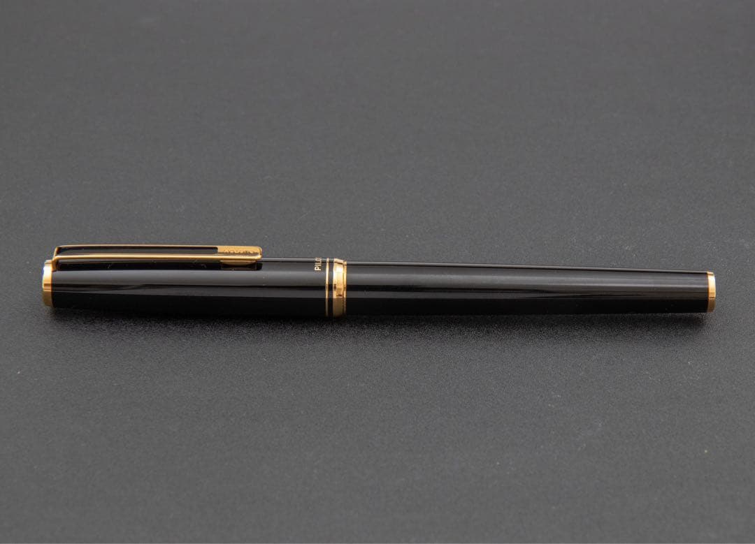 Pilot fountain pen with 14k gold fine nib, black and gold body, and blue-black ink cartridge included