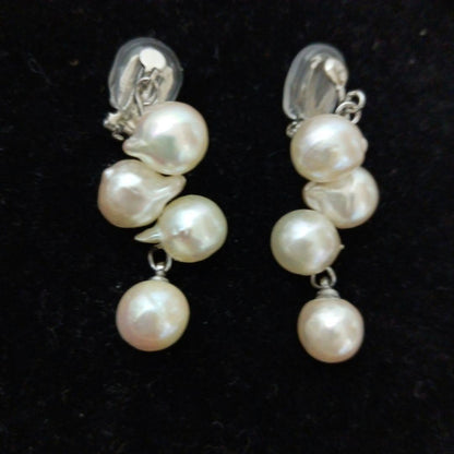 Akoya pearl necklace and earrings set with 8-9mm pearls and flower motif clasp on a white background