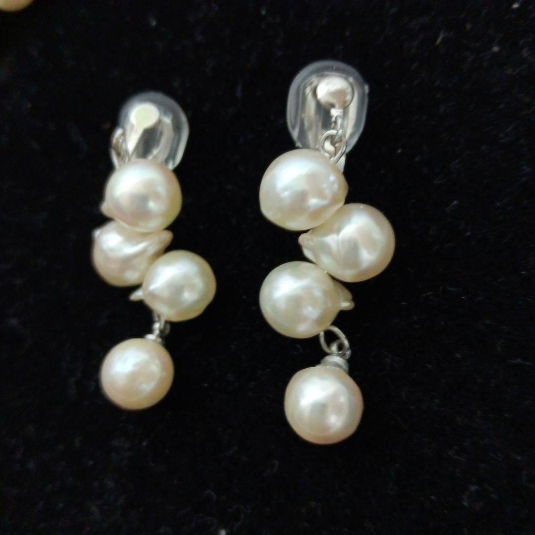 Akoya pearl necklace and earrings set with 8-9mm pearls and flower motif clasp on a white background