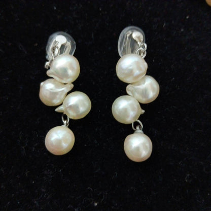 Akoya pearl necklace and earrings set with 8-9mm pearls and flower motif clasp on a white background