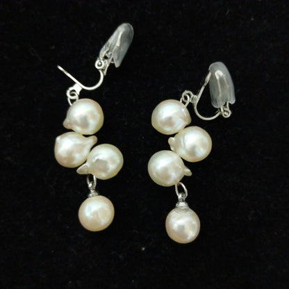 Akoya pearl necklace and earrings set with 8-9mm pearls and flower motif clasp on a white background