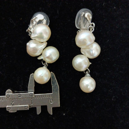 Akoya pearl necklace and earrings set with 8-9mm pearls and flower motif clasp on a white background