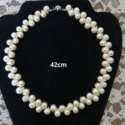 Akoya pearl necklace and earrings set with 8-9mm pearls and flower motif clasp on a white background