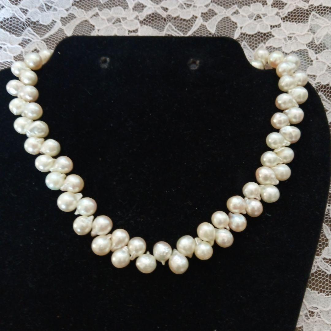 Akoya pearl necklace and earrings set with 8-9mm pearls and flower motif clasp on a white background