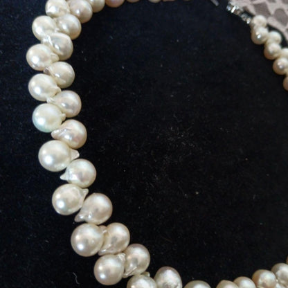 Akoya pearl necklace and earrings set with 8-9mm pearls and flower motif clasp on a white background