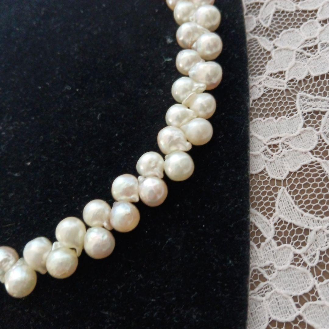 Akoya pearl necklace and earrings set with 8-9mm pearls and flower motif clasp on a white background
