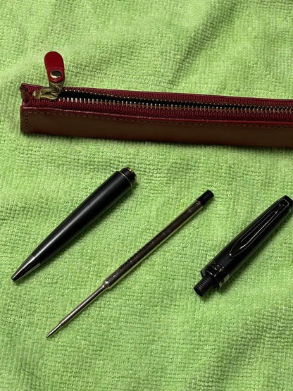 Red leather pencil case measuring 14 cm with a black Waterman pen set displayed together
