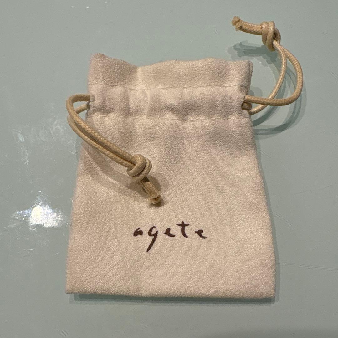 Agete necklace with chain and shell charm paired with hook earrings featuring an octagonal motif and storage pouch