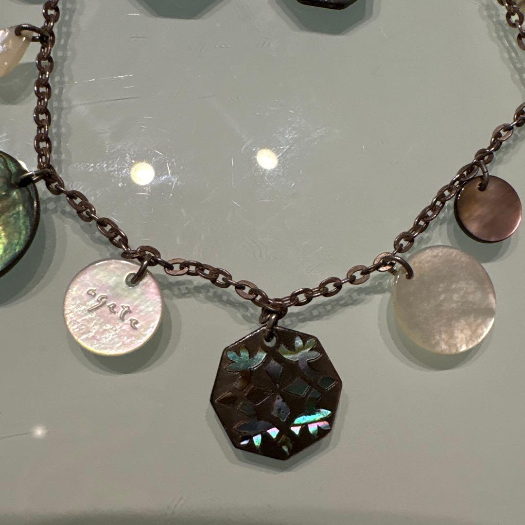 Agete necklace with chain and shell charm paired with hook earrings featuring an octagonal motif and storage pouch