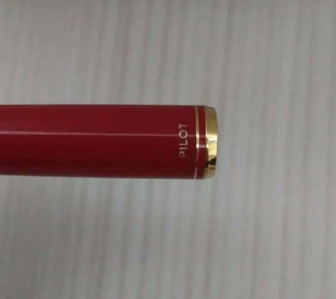Red Pilot fountain pen with gold trim and fine tip, cartridge type, shown on white background