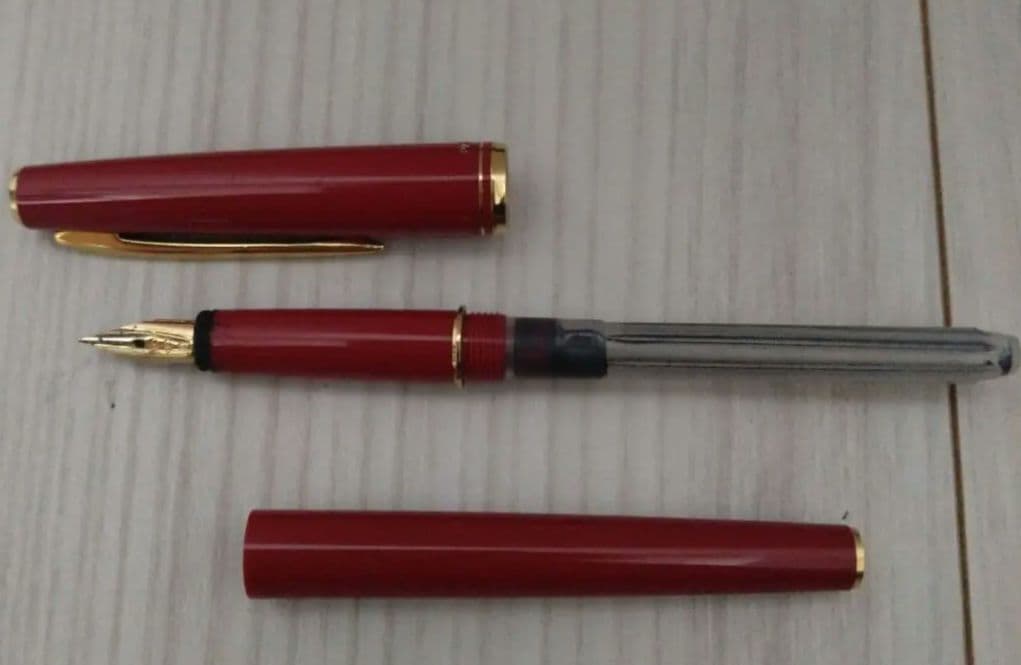 Red Pilot fountain pen with gold trim and fine tip, cartridge type, shown on white background