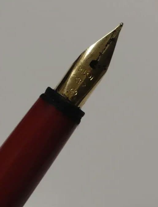 Red Pilot fountain pen with gold trim and fine tip, cartridge type, shown on white background