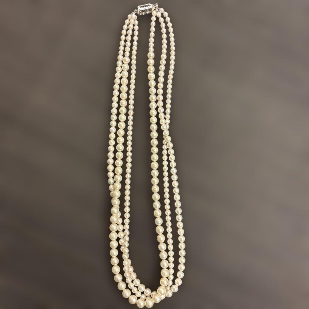 Akoya pearl necklace with three strands of varying sized white pearls, approximately 45cm long, displayed with case