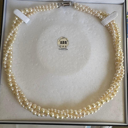 Akoya pearl necklace with three strands of varying sized white pearls, approximately 45cm long, displayed with case
