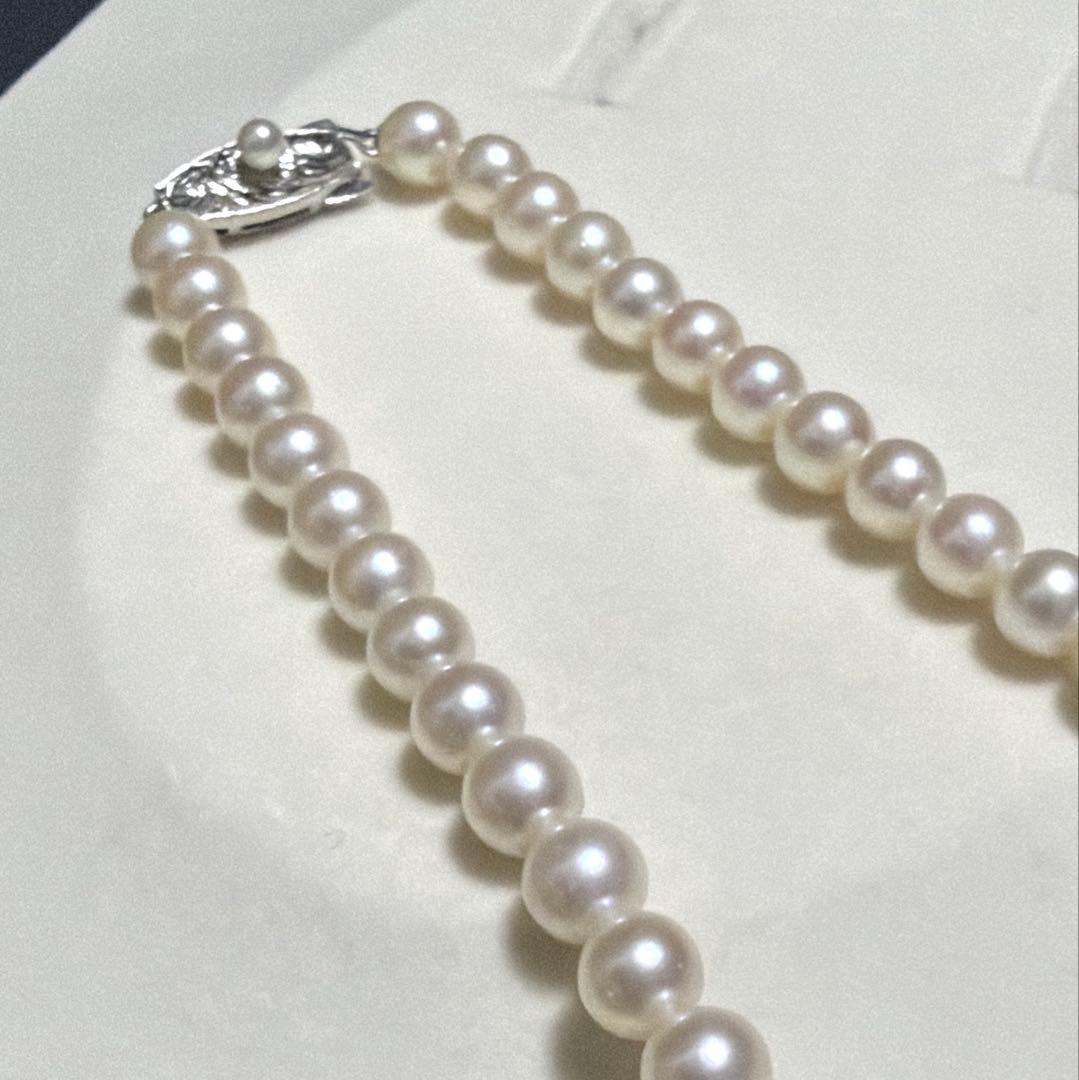 Tasaki Akoya pearl long necklace with 6.5mm genuine pearls and high luster on a white background