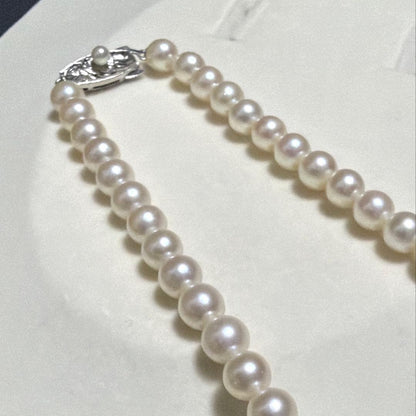 Tasaki Akoya pearl long necklace with 6.5mm genuine pearls and high luster on a white background