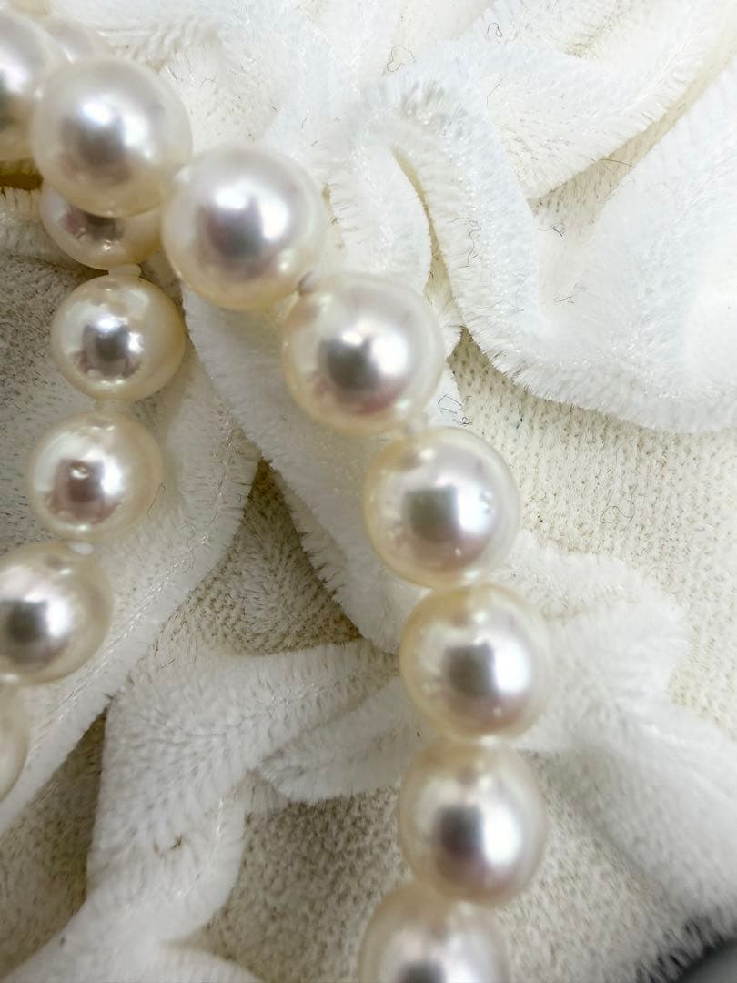 Hon-Pearl Akoya pearl necklace with 7mm white round beads displayed on a black background