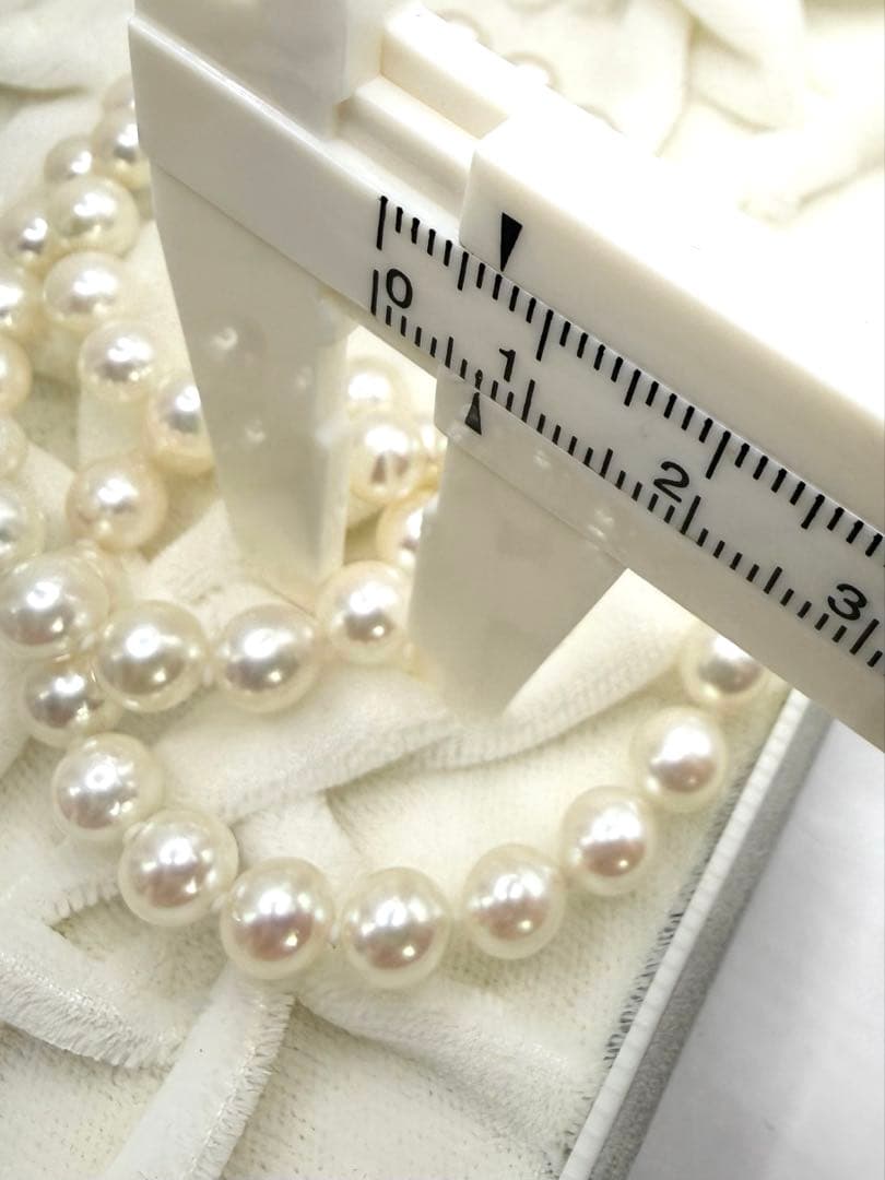Hon-Pearl Akoya pearl necklace with 7mm white round beads displayed on a black background