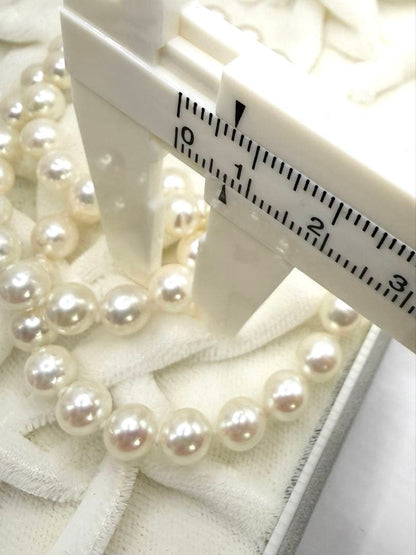 Hon-Pearl Akoya pearl necklace with 7mm white round beads displayed on a black background