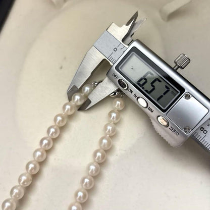 Newly polished white Akoya pearl necklace with 7mm pearls, 42cm length, laid flat