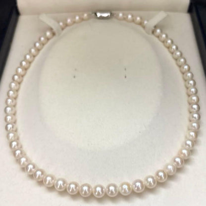 Newly polished white Akoya pearl necklace with 7mm pearls, 42cm length, laid flat