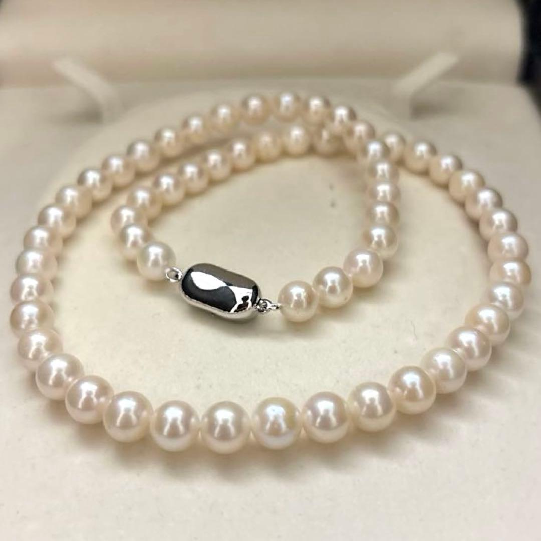 Newly polished white Akoya pearl necklace with 7mm pearls, 42cm length, laid flat