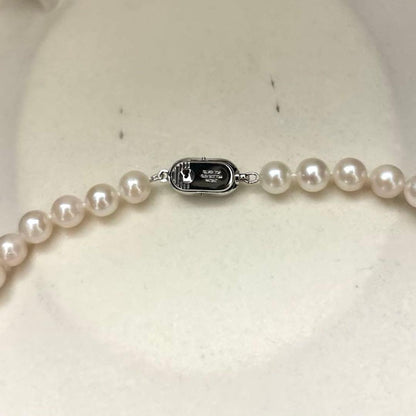 Newly polished white Akoya pearl necklace with 7mm pearls, 42cm length, laid flat