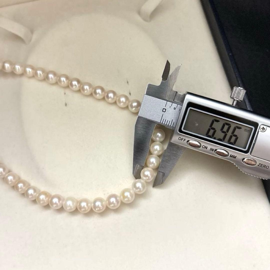 Newly polished white Akoya pearl necklace with 7mm pearls, 42cm length, laid flat