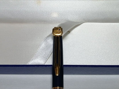Hello Kitty Waterman ballpoint pen with extra ink refill, external box, and vintage storage case showing yellowing