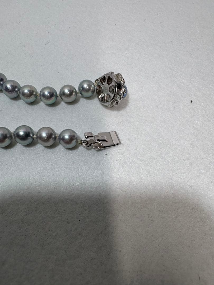Akoya gray pearl necklace with silver chain on a white background