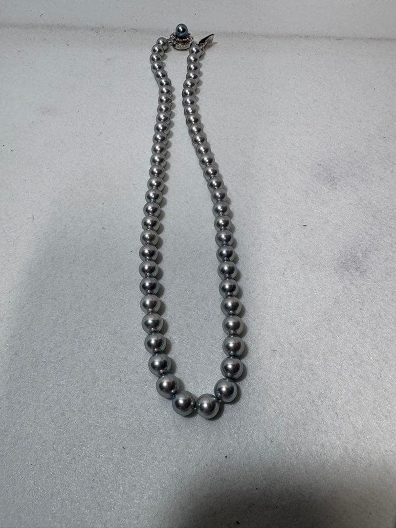 Akoya gray pearl necklace with silver chain on a white background