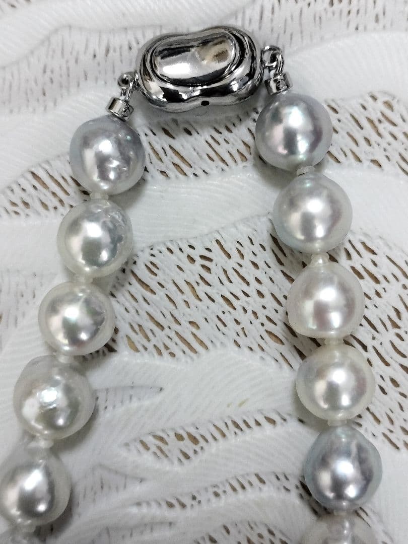 Akoya pearl large round necklace with multi-color pearls and silver push clasp on white background