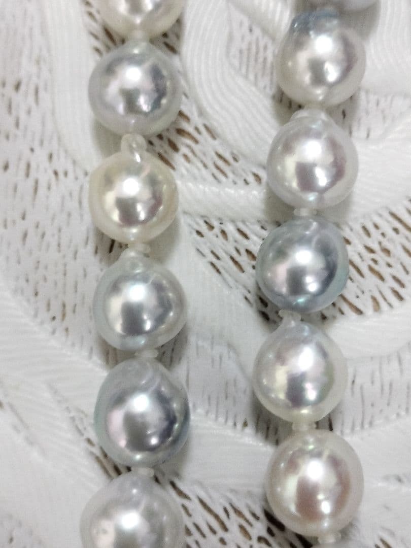 Akoya pearl large round necklace with multi-color pearls and silver push clasp on white background
