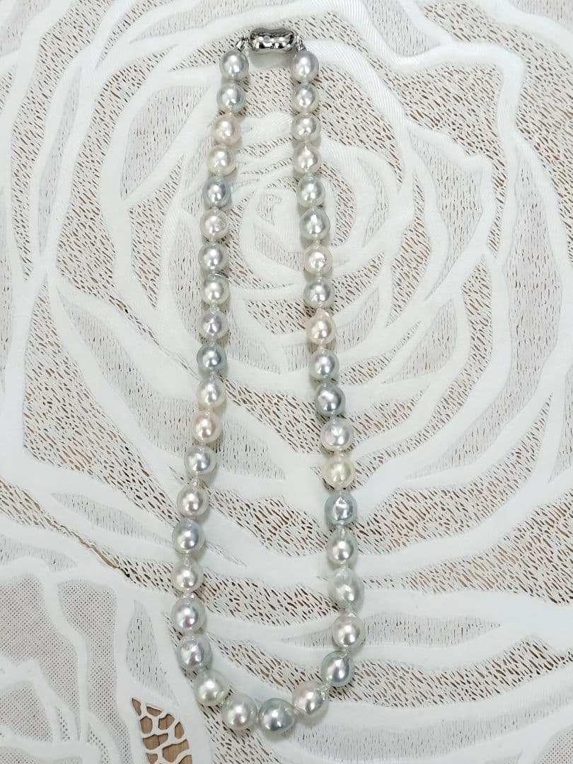 Akoya pearl large round necklace with multi-color pearls and silver push clasp on white background