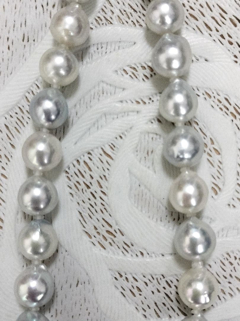 Akoya pearl large round necklace with multi-color pearls and silver push clasp on white background