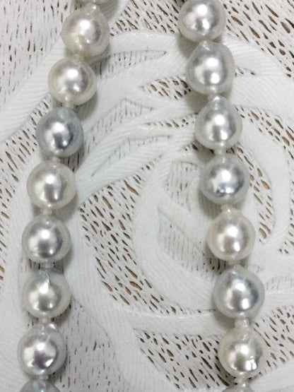 Akoya pearl large round necklace with multi-color pearls and silver push clasp on white background
