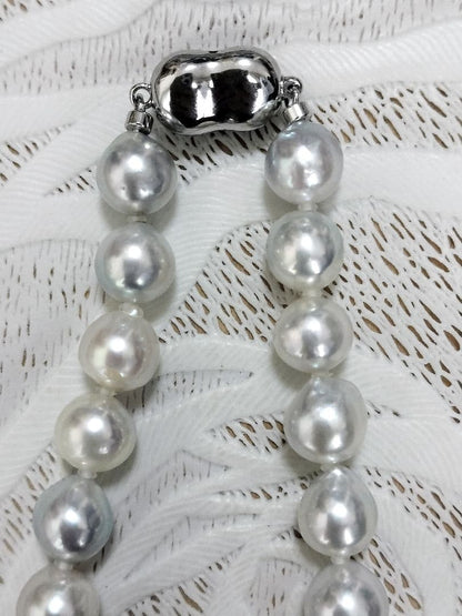 Akoya pearl large round necklace with multi-color pearls and silver push clasp on white background