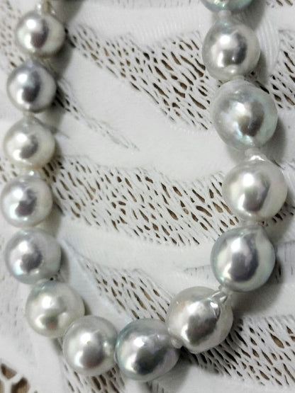 Akoya pearl large round necklace with multi-color pearls and silver push clasp on white background