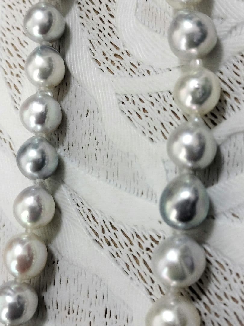 Akoya pearl large round necklace with multi-color pearls and silver push clasp on white background