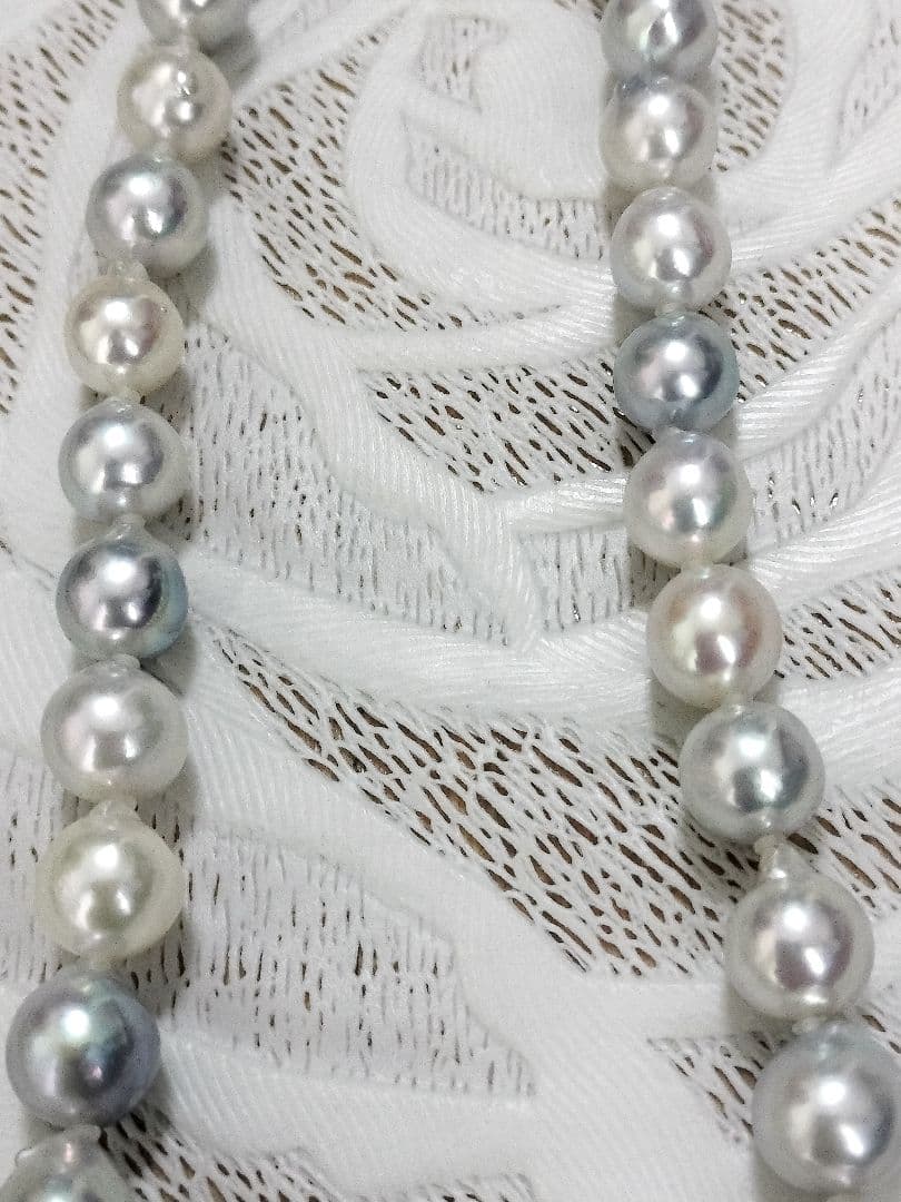 Akoya pearl large round necklace with multi-color pearls and silver push clasp on white background